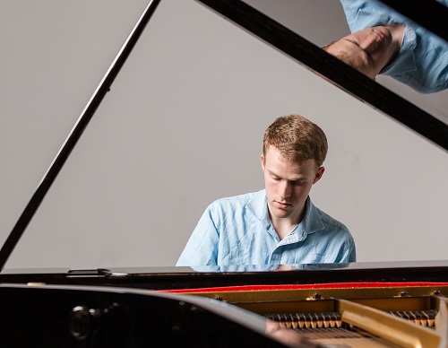 Photo of CJ Madsen playing a grand piano