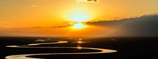 Photo of a river reflecting the golden light of a sunset