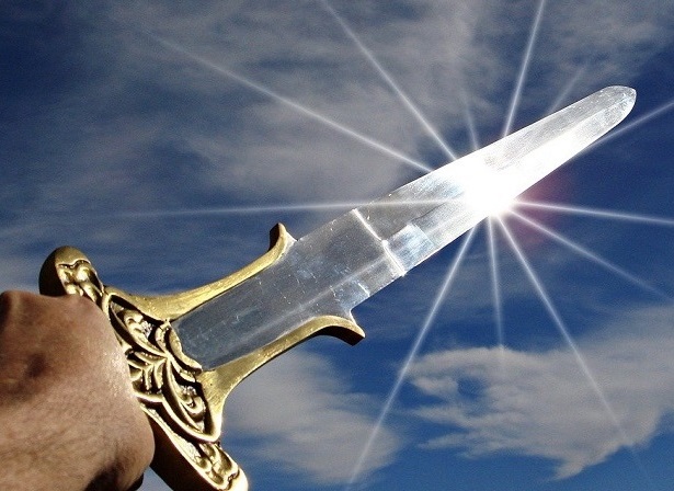 Photo of a sword being thrust into the air in victory, scattering sunbeams