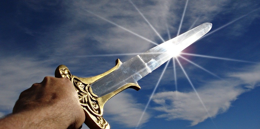 Photo of a sword being thrust into the air in triumph, scattering sun rays in every direction